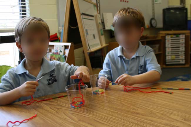 Stringing straw pieces to make long and short snakes